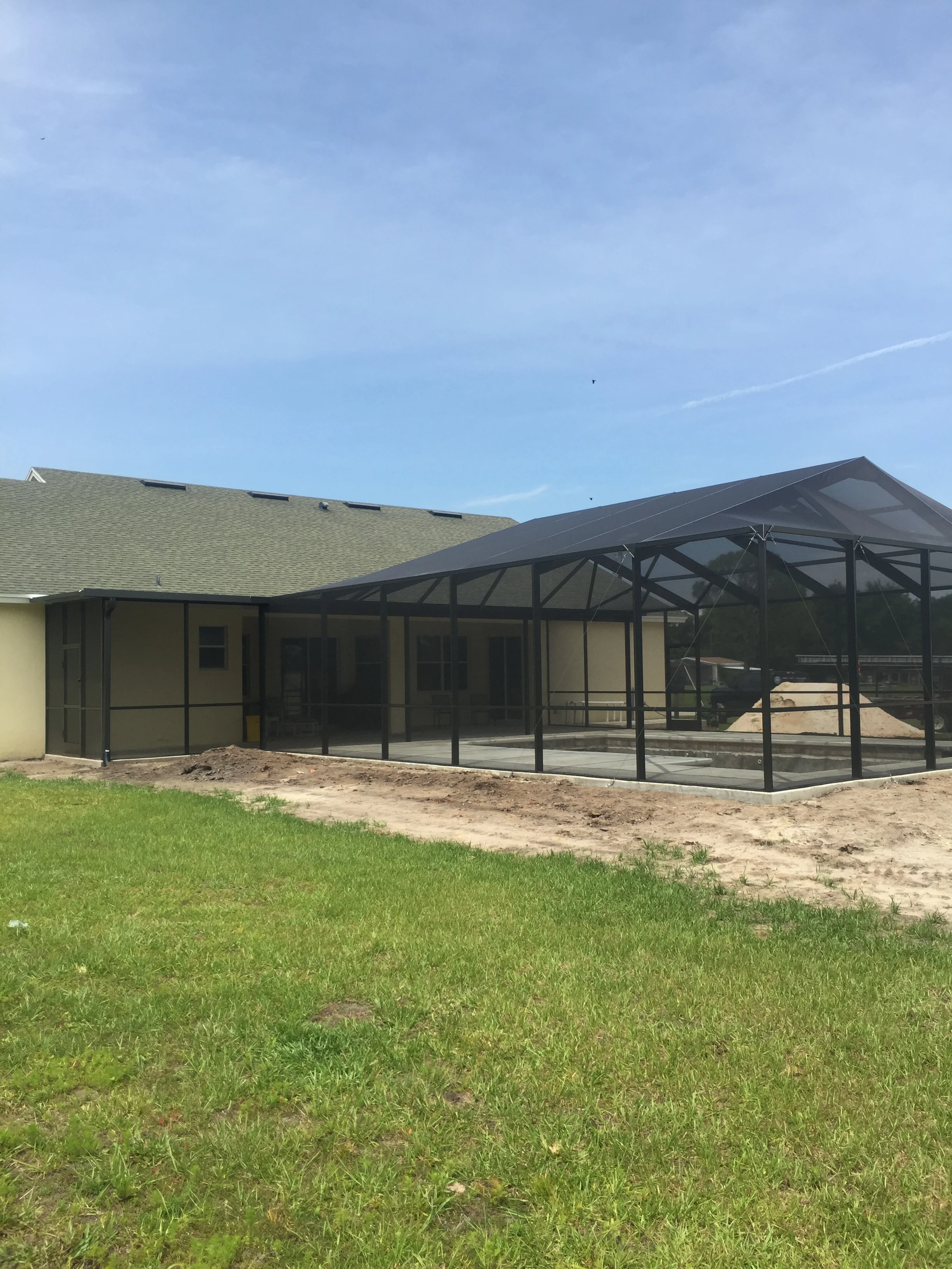 Aluminum-framed screened patio with gable roof and full-length screen panels attached to home